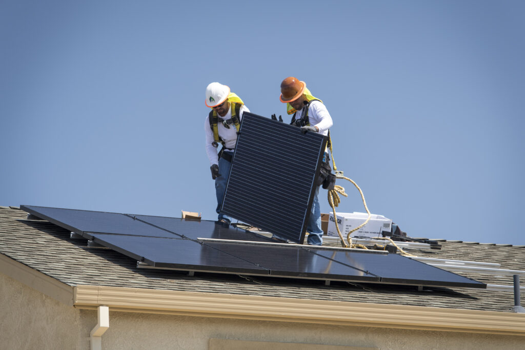 Contractors install SunRun Inc. solar panels on the roof of a new home at the Westline Homes Willowood Cottages community in Sacramento, California, U.S., on Wednesday, Aug. 15, 2018. California is the first state in the U.S. to require solar panels on almost all new homes as part of a mandate to take effect in 2020. Photographer: David Paul Morris/Bloomberg